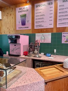 the inside of a coffee shop with menus on the wall and pink counter tops