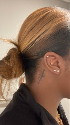 a woman with tattoos on her neck and ear