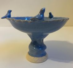 a blue ceramic bowl with two birds on the top and one bird in the bottom