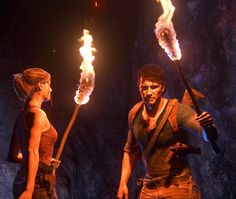 a man and woman holding torches in the dark with flames coming out of their mouths