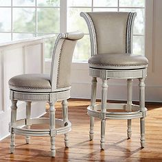 two white stools sitting next to each other on top of a hard wood floor