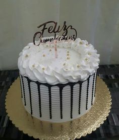 a cake with white frosting and black icing on top that says feli's congratulations