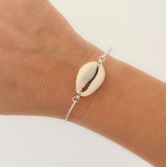 "Cowrie Shell Bracelet - Cowrie Shell Bracelet - Hawaiian Shell Bangle Bracelet - Hawaiian Shell Jewelry A genuine white cowrie shell will be transformed into a dainty & delicate Hawaiian shell bracelet with choice of silver filled, sterling silver, brass, 14k gold filled or 14k rose gold filled bangle band. This Hawaiian bracelet shell bangle stacks great with other bangles from my collection as you can see from the 4th picture. Have fun stacking your cowrie shell bangle / conch shell bangl Trendy Silver Shell Jewelry With Oyster Bracelet, White Shell-shaped Bracelet As A Gift, White Shell-shaped Bracelet For Gift, Handmade Silver Shell Bracelets, Handmade Shell-shaped Silver Bracelets, Shell Strand Bracelets As Gift, Adjustable Silver Shell-shaped Jewelry, Elegant Shell-shaped Bracelet, Elegant Shell-shaped Bracelet Gift