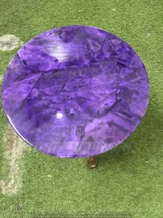 a purple table sitting on top of a green field