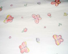 a white sheet with pink and yellow butterfly designs on it, along with other butterflies