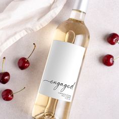 a bottle of wine with some cherries around it