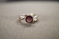 a close up of a ring with a stone in the middle on a white surface