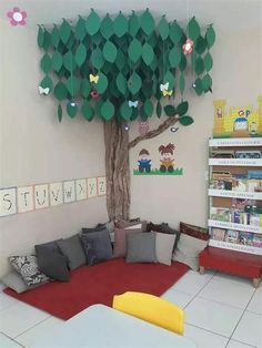 a room with a tree, couch and bookshelf