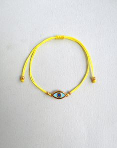 Martis bracelet, Evil eye bracelet Gold enamel charm, Waxed cord March bracelets, Red and White, Twisted string, Greek Tradition Unisex gift The March bracelet is an ancient Greek custom. From the beginning of March, people wear a bracelet made of white and red twisted thread. According to the tradition, the March bracelet protects those from burning of the first sun of spring. The last day of March,the bracelet is left on trees so that swallows can use it for building their nests. Bracelet is m Gold Braided Evil Eye Bracelet As A Gift, Gold Braided Bracelet With Evil Eye For Gift, Gold Braided Bracelet With Evil Eye As Gift, Gold Evil Eye Bracelet With Adjustable Length As Gift, Adjustable Yellow Bracelets As Gift, Adjustable Yellow Bracelets For Gifts, Adjustable Yellow Braided Bracelets As Gift, Yellow Resizable Jewelry For Friendship, Gold Evil Eye Bracelet With Sliding Knot As Gift