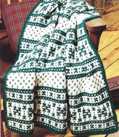 a green and white blanket sitting on top of a wooden chair