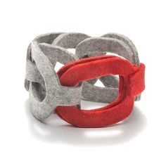 a close up of a bracelet on a white background with red and grey rings in the middle