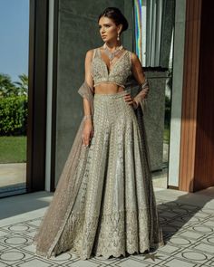 Buy Heavily Embellished Bridal Net Lehenga Choli in Premium Quality Details with Embellishments paired with Heavy Dupatta. Customizable. Fast Shipping Hand Embellished Gold Lehenga For Wedding, Gold Hand Embellished Lehenga For Wedding, Silver Hand Embellished Floor-length Lehenga, Silver Hand-embellished Floor-length Lehenga, Hand Embellished Kundan Lehenga Floor-length, Silver Semi-stitched Lehenga With Dabka Work, Silver Dabka Work Sets For Wedding, Silver Wedding Sets With Dabka Work, Festive Floor-length Gown For Wedding Reception