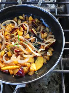 a wok filled with food sitting on top of a stove