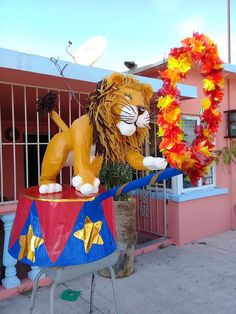 a statue of a lion on top of a circus float in front of a building