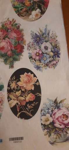 four round stickers with flowers on them sitting on top of a piece of paper