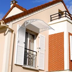 an orange brick building with white shutters