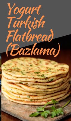 a stack of flatbreads sitting on top of a wooden cutting board