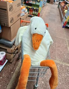 a stuffed duck sitting in a shopping cart