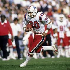 a football player running with the ball in his hand and people watching from the stands