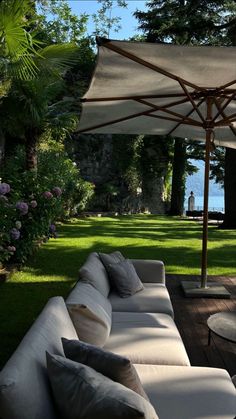 an outdoor living area with couches and umbrellas