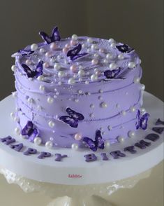 a cake with purple icing and butterflies on it