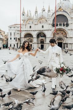 a bride and groom are surrounded by pigeons