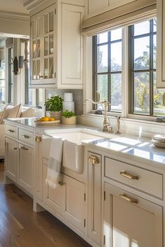 a kitchen filled with lots of white cabinets and counter top space next to a window