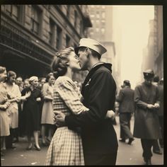 a man and woman kissing in front of a crowd of people on a city street