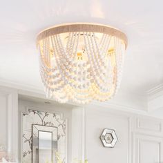 a chandelier hanging from the ceiling in a white bathroom with marble counter tops