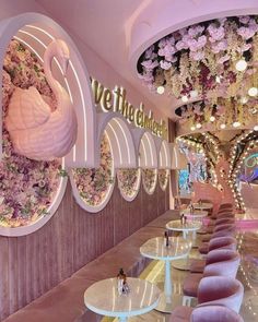 the interior of a restaurant decorated with pink flowers