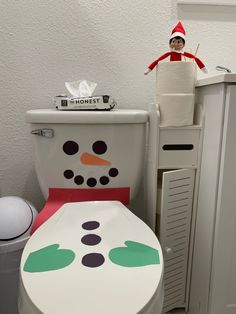 an elf is sitting on top of a toilet seat in front of a white wall