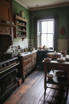 an old fashioned kitchen with wooden floors and green walls, has many dishes on the table