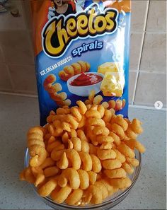 some cheetos are sitting on a counter next to a bag of chips