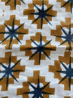 an orange and blue fabric with black stars on the top, in different sizes and shapes