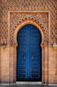 a blue door is in front of a stone building with an intricate design on it