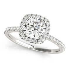 a white gold halo style engagement ring with pave set diamonds on the shoulders and sides