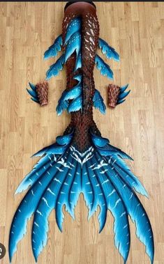 this is an image of a blue and brown feathered object on the floor with pine cones