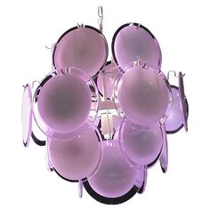 a purple light hanging from the ceiling with lots of pans on it's sides