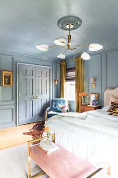 a bedroom with blue walls and white bedding