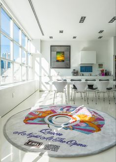 a large circular rug in the middle of a room with chairs and tables around it