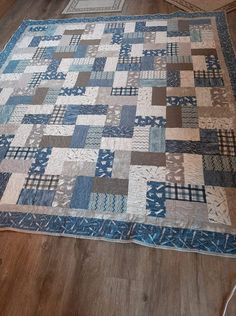 a blue and beige quilt on the floor