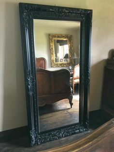 a large mirror sitting on top of a wooden floor