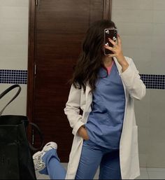 a woman taking a selfie in front of a bathroom mirror with her cell phone