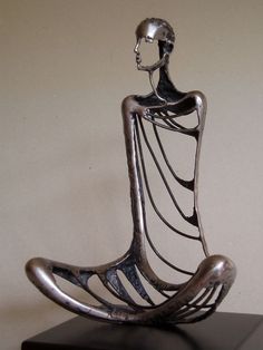 a metal sculpture sitting on top of a wooden table