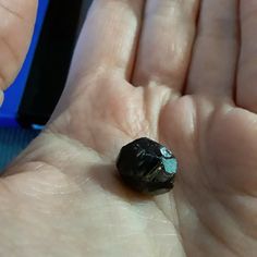 a person holding out their hand with a rock in it's left palm area