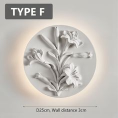 a white wall mounted with flowers in the center and an inscription type f on it