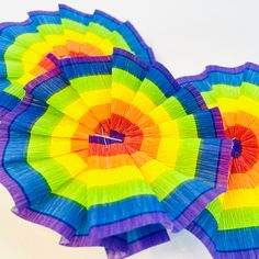 two colorful parasols sitting next to each other on top of a white surface