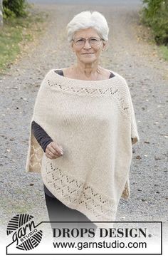 an older woman is walking down the road wearing a ponchy with laces on it