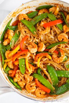 stir fried noodles with shrimp and vegetables in a pan