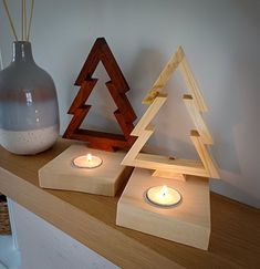 two wooden candles are sitting on a shelf next to a vase and some wood ornaments